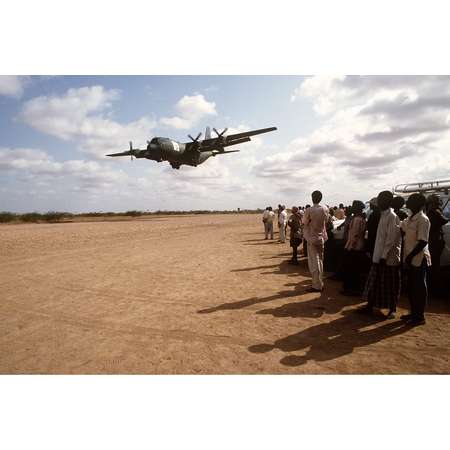 LAMINATED POSTER Local Kenyan workers watch a C-130 Hercules from the 314th Air Lift Wing, Little Rock AFB, Arkansas, Poster Print 24 x 36 thumb